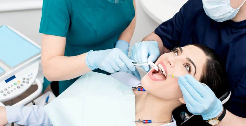 woman receiving dental work from two dentists