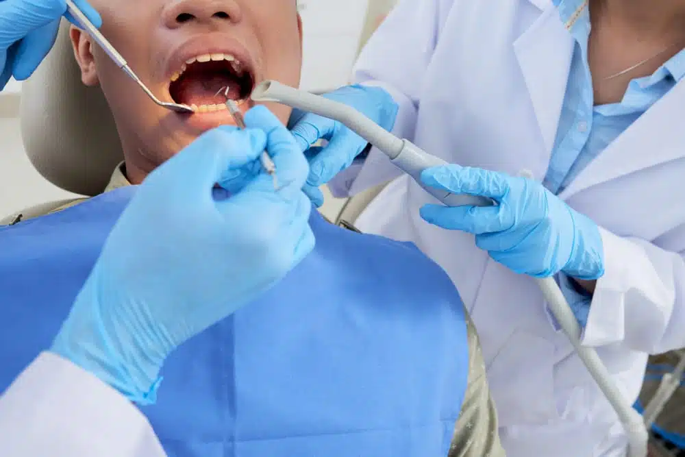 patient receiving treatment by two dentists